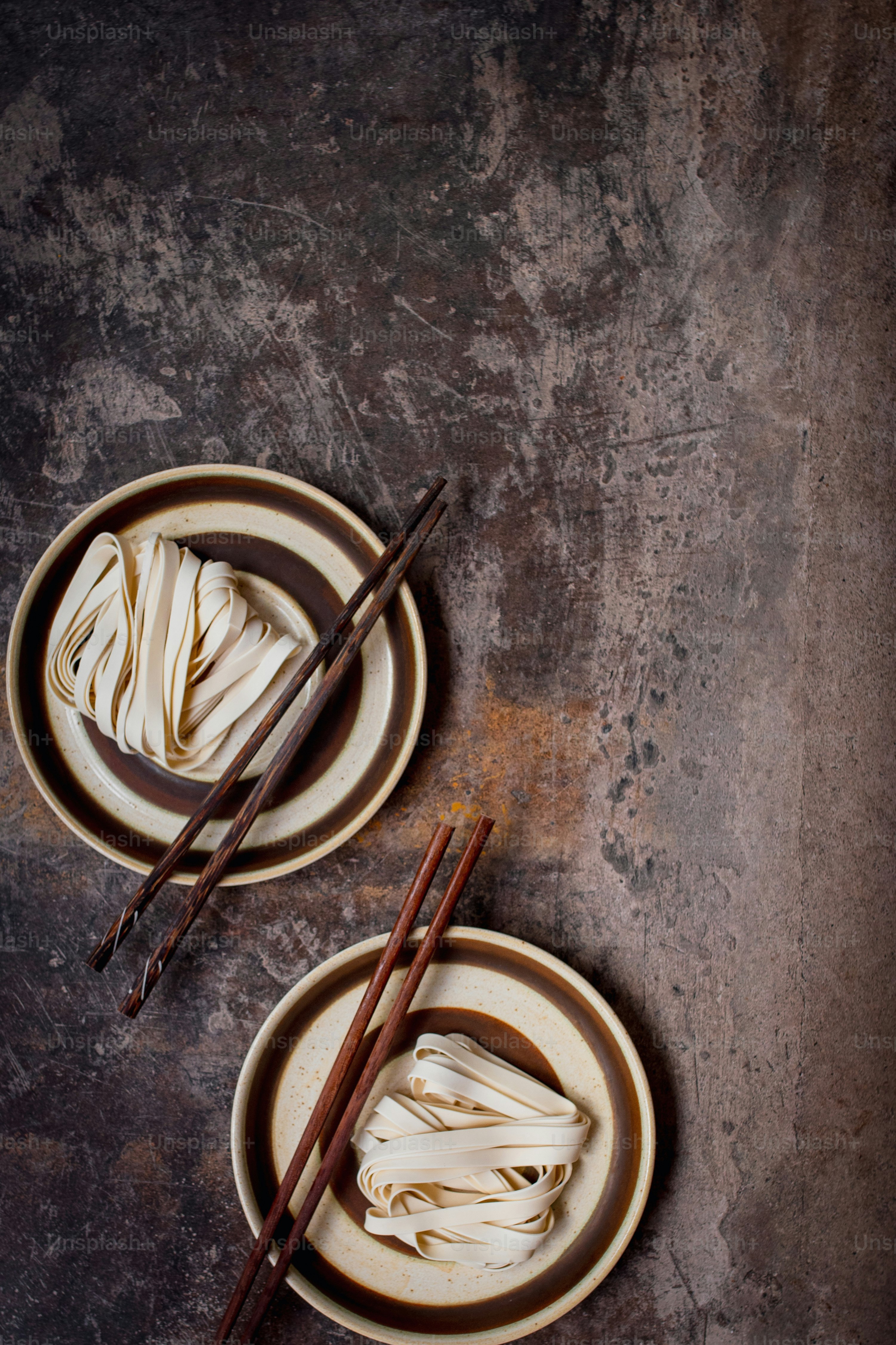 Dos platos de comida con palillos sobre una mesa