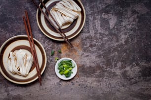 two plates of food on a table with chopsticks