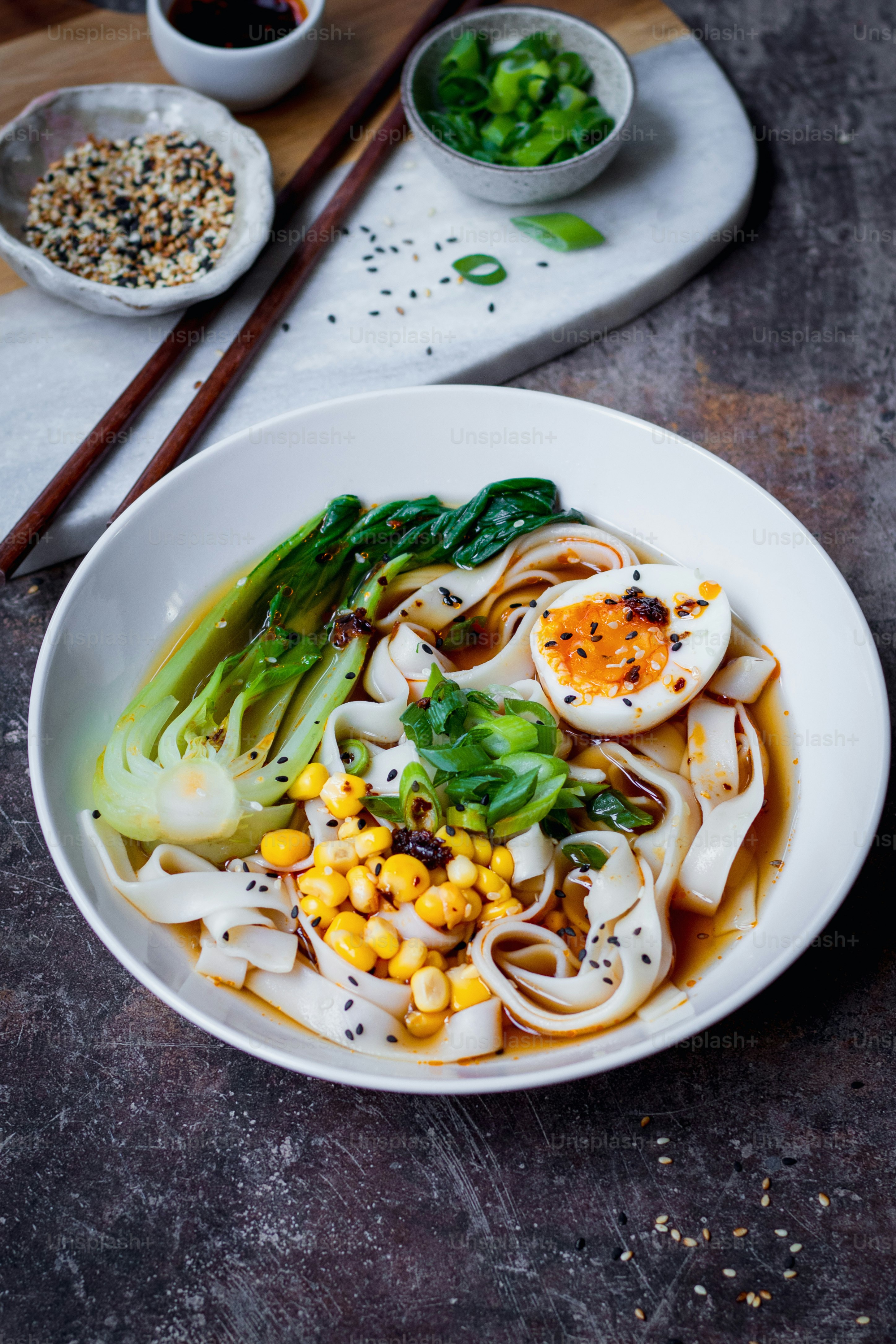 a white bowl filled with noodles and vegetables