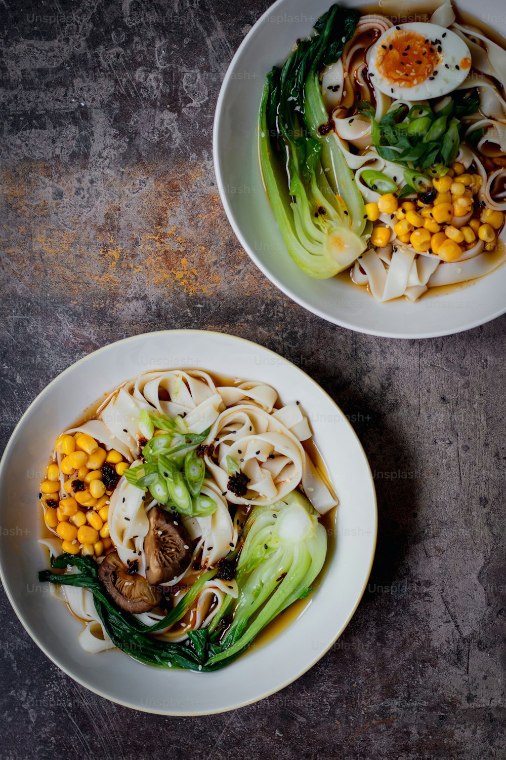 テーブルの上に麺と野菜の2つのボウル