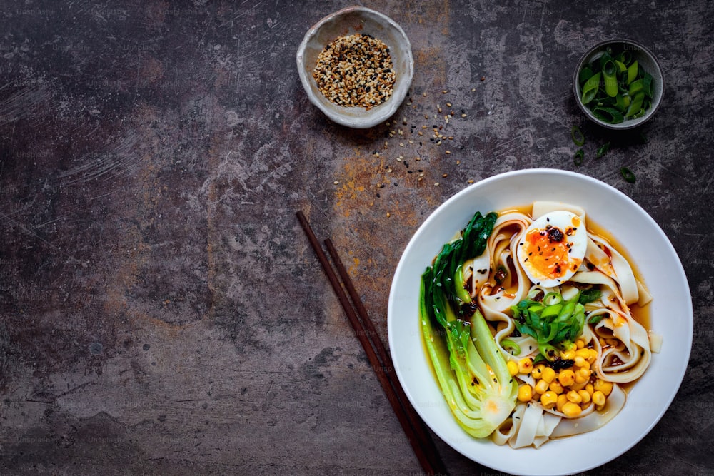 a white bowl filled with noodles and vegetables