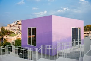 Un edificio rosa y púrpura con escaleras que conducen a él
