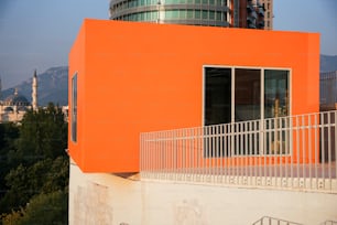 an orange building with a balcony and railing