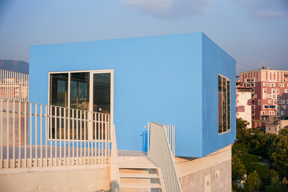 a blue building with stairs leading up to it