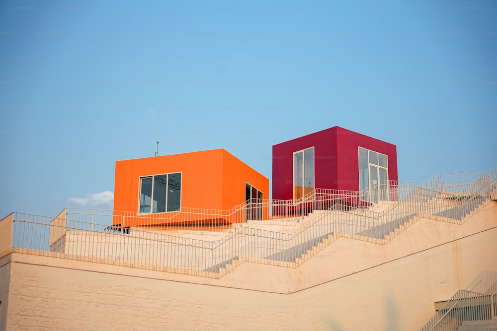 Un par de edificios naranjas y rojos sentados en la parte superior de un edificio