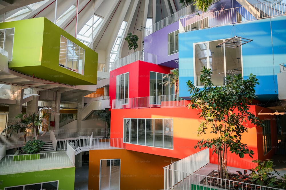 Un edificio multicolor con un árbol en su interior