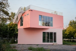 Una casa rosada con una escalera que sube por el costado de la misma