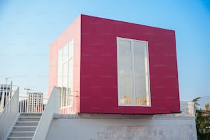 Una caja roja sentada en la parte superior de un edificio