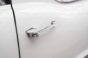 Un primo piano di una maniglia della porta su un'auto bianca