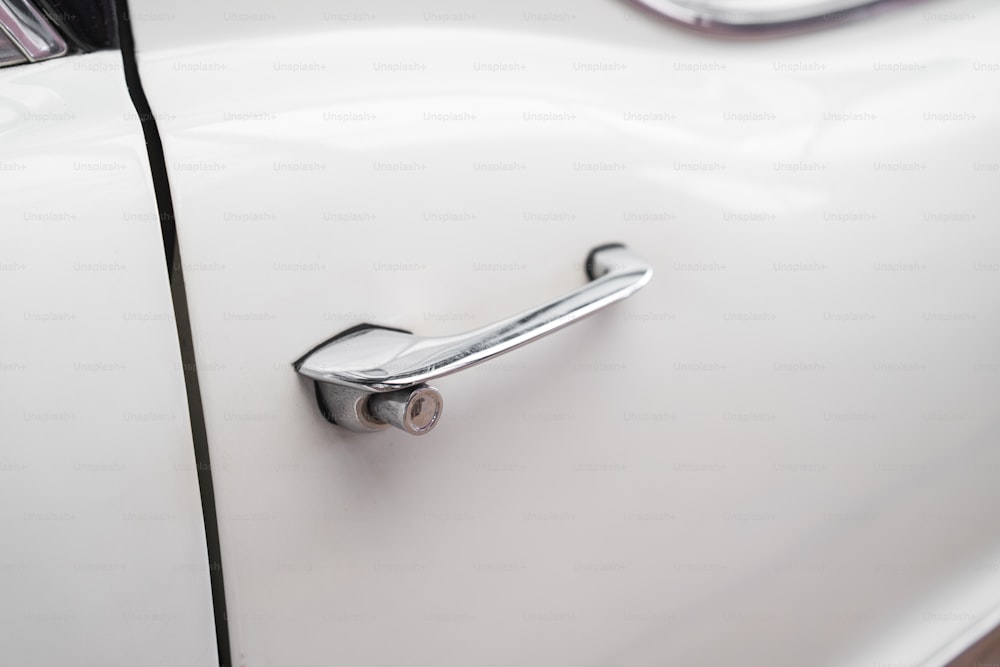 a close up of a door handle on a white car