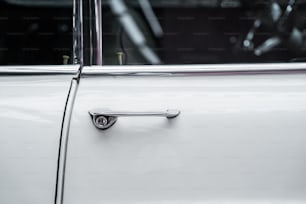 a close up of a door handle on a white car