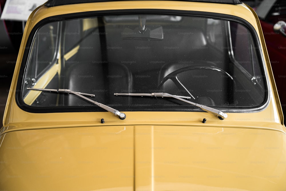 ein gelbes Auto mit schwarzem Verdeck und einer Schere, die aus dem