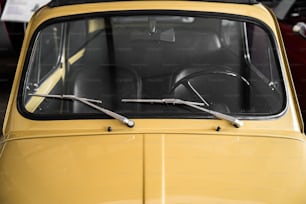 a yellow car with a black top and a pair of scissors sticking out of the