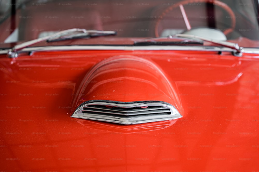 um close up da frente de um carro vermelho