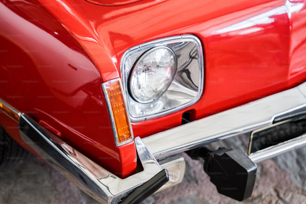 um close up da dianteira de um carro vermelho