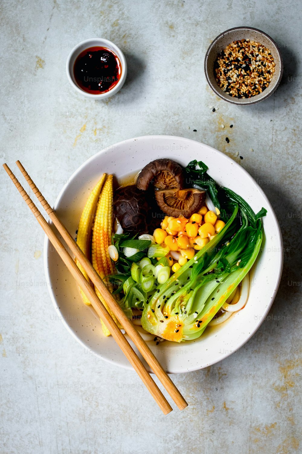 a bowl of food with chopsticks on a table