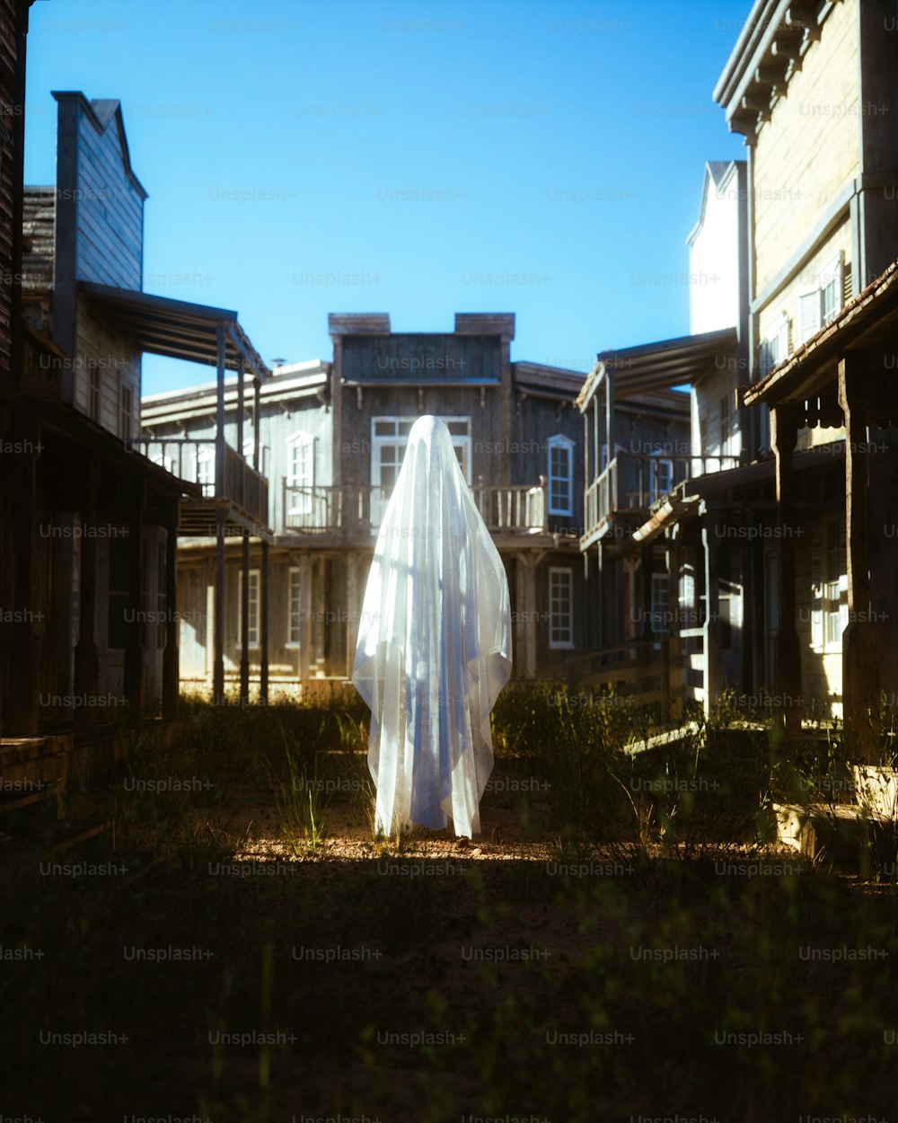 Un fantasma camina por un patio frente a una hilera de casas