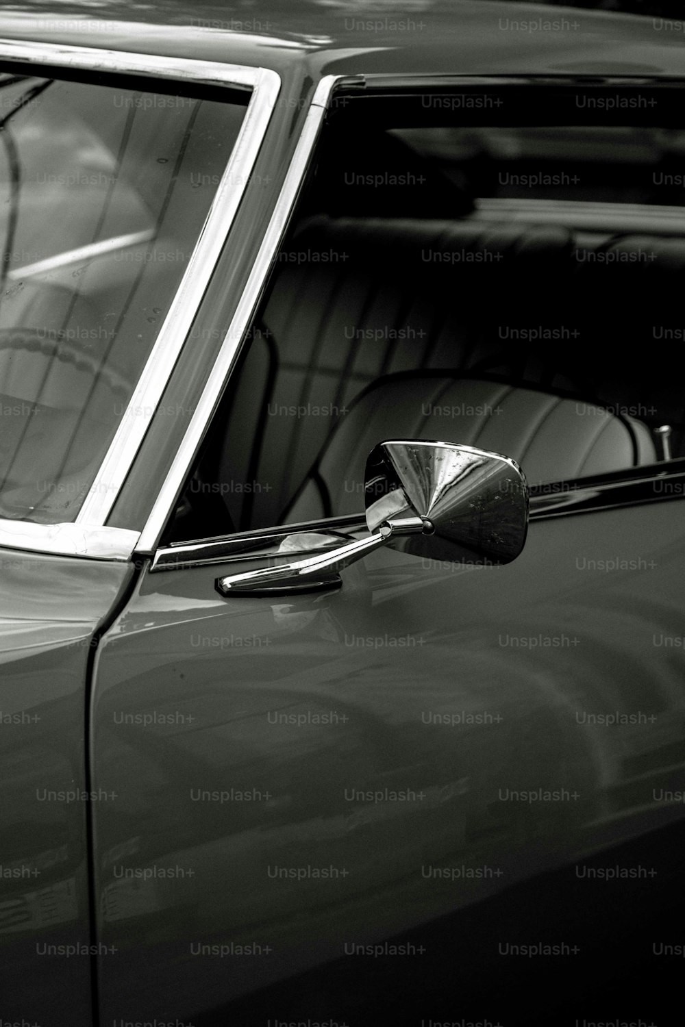 a black and white photo of a car's side mirror