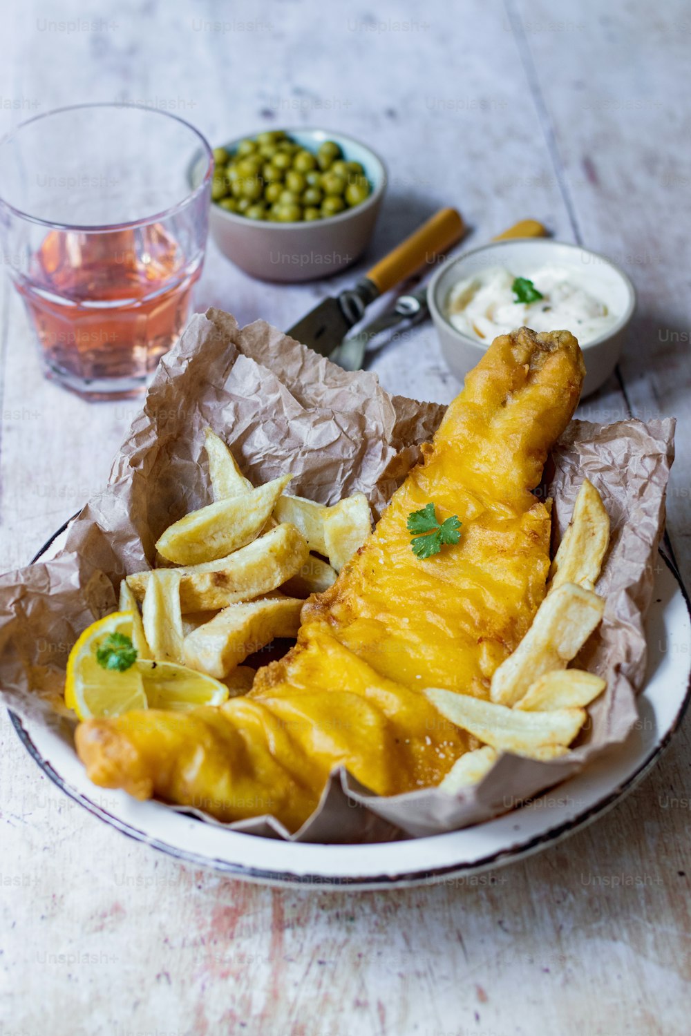um prato de peixe e batatas fritas sobre uma mesa