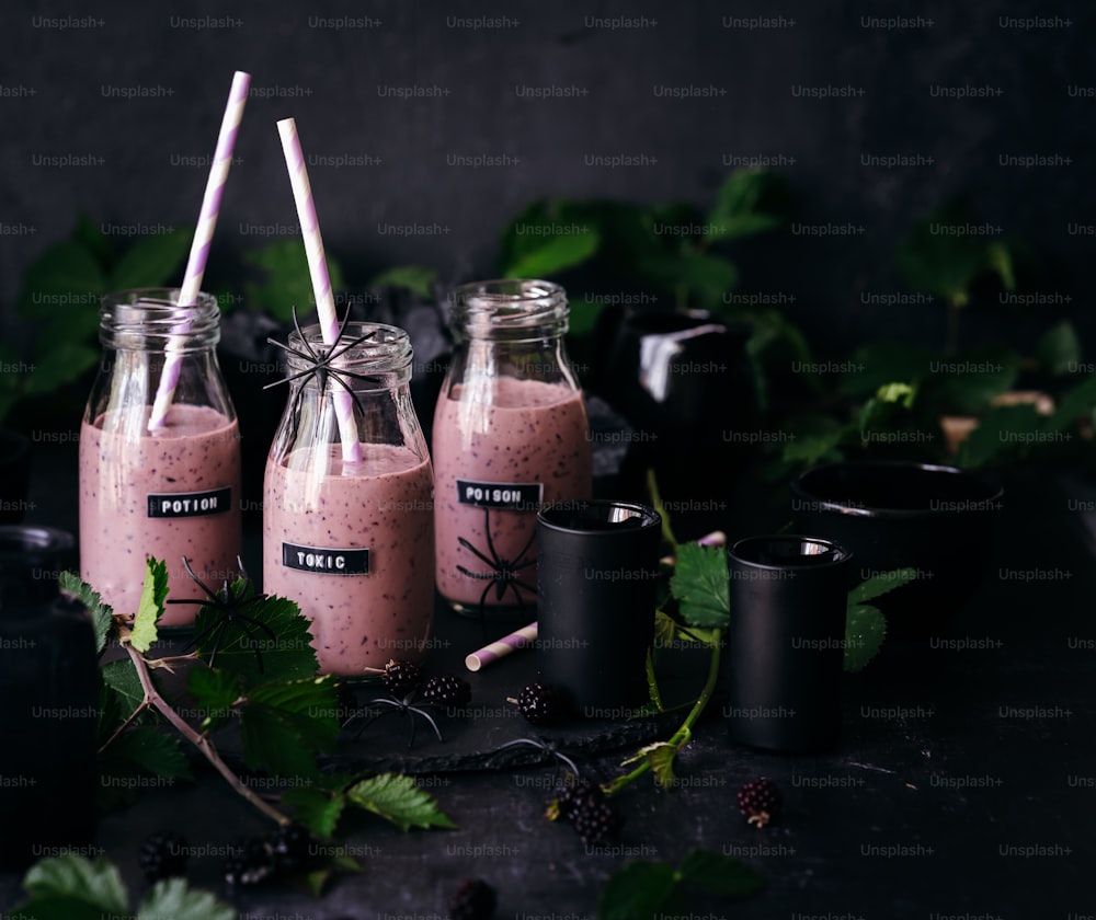 three mason jars filled with pink smoothie on top of a table