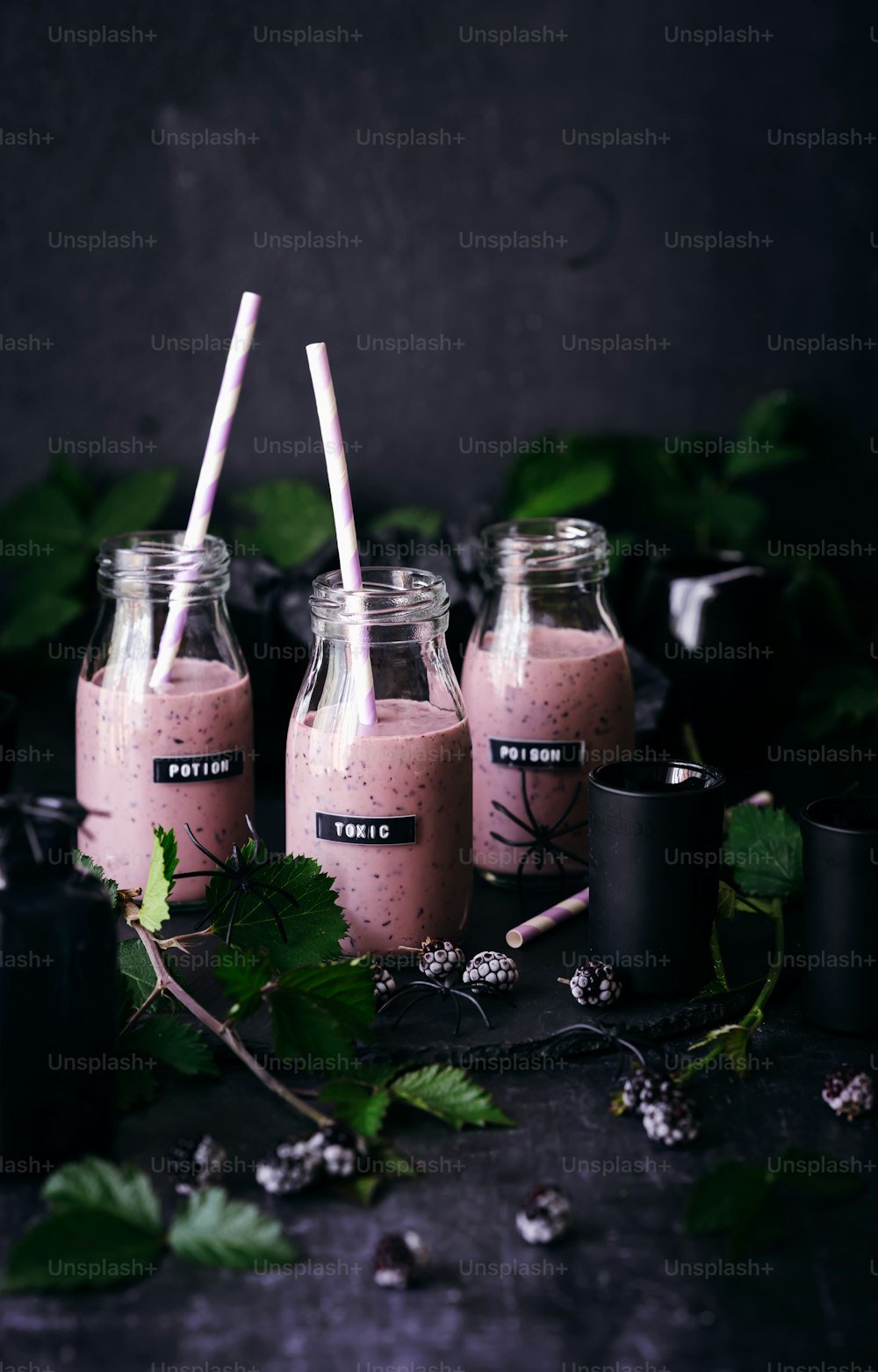 three mason jars filled with pink smoothie on top of a table