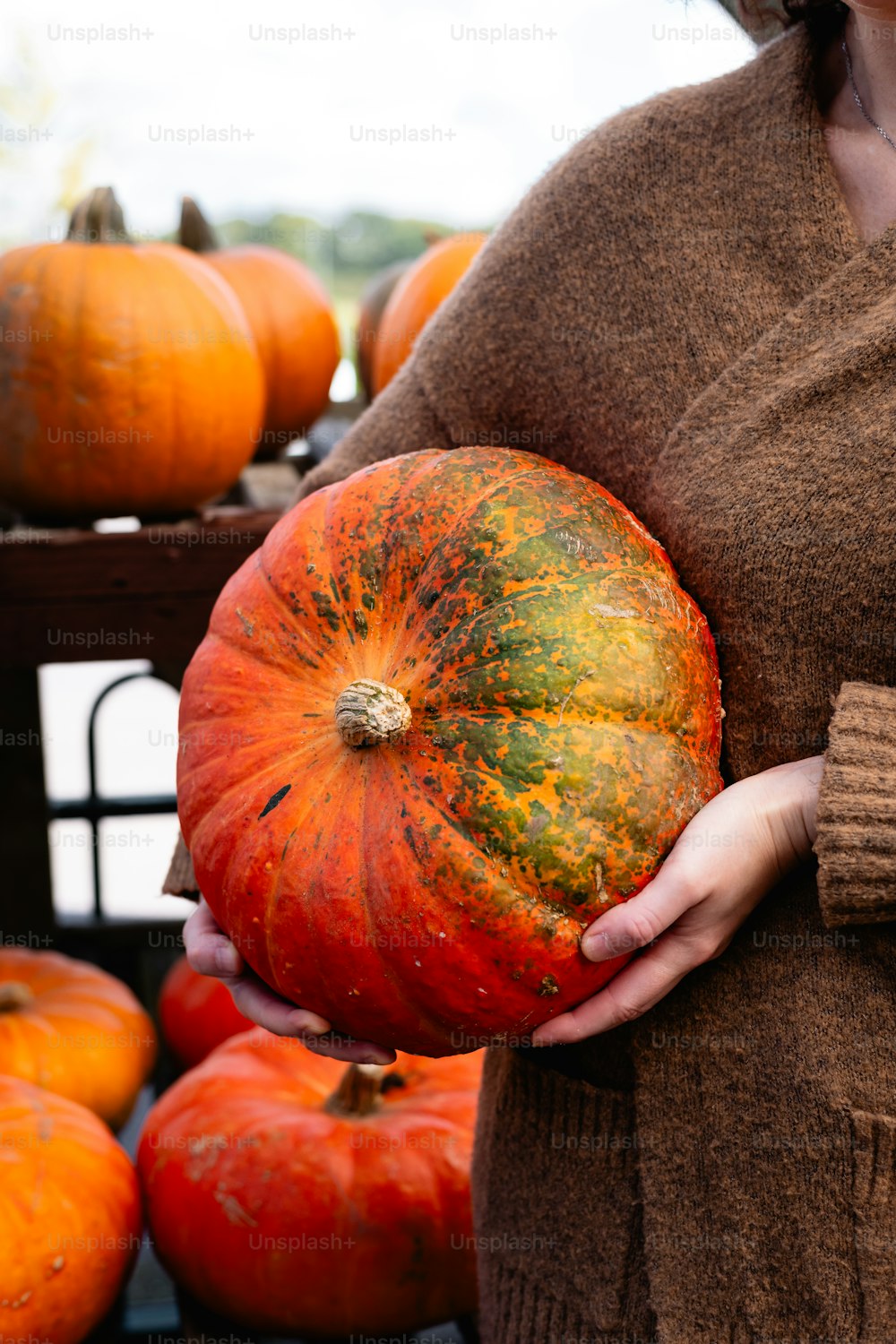 a woman holding a large pumpkin in her hands
