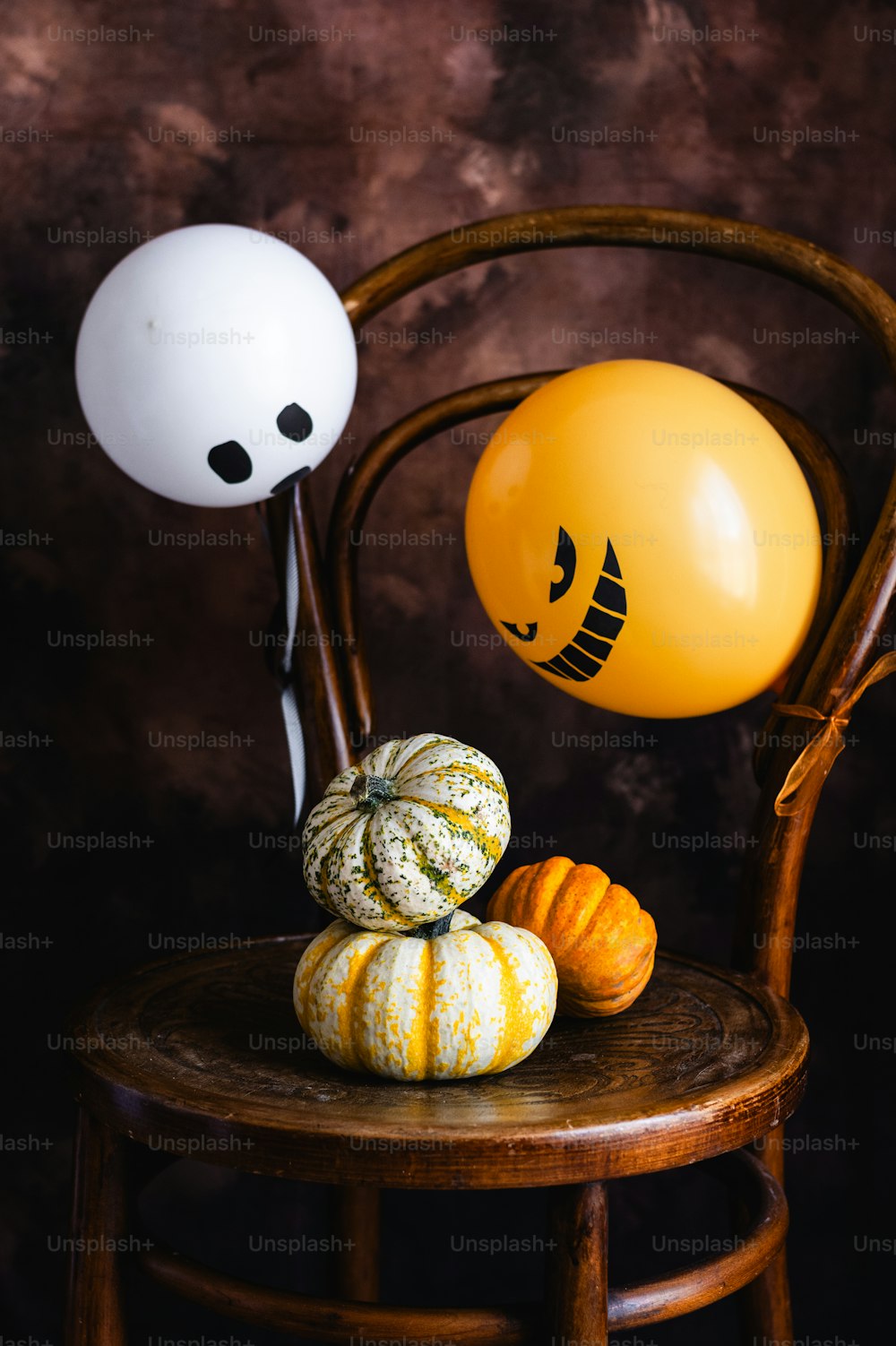 a chair with balloons and pumpkins on it
