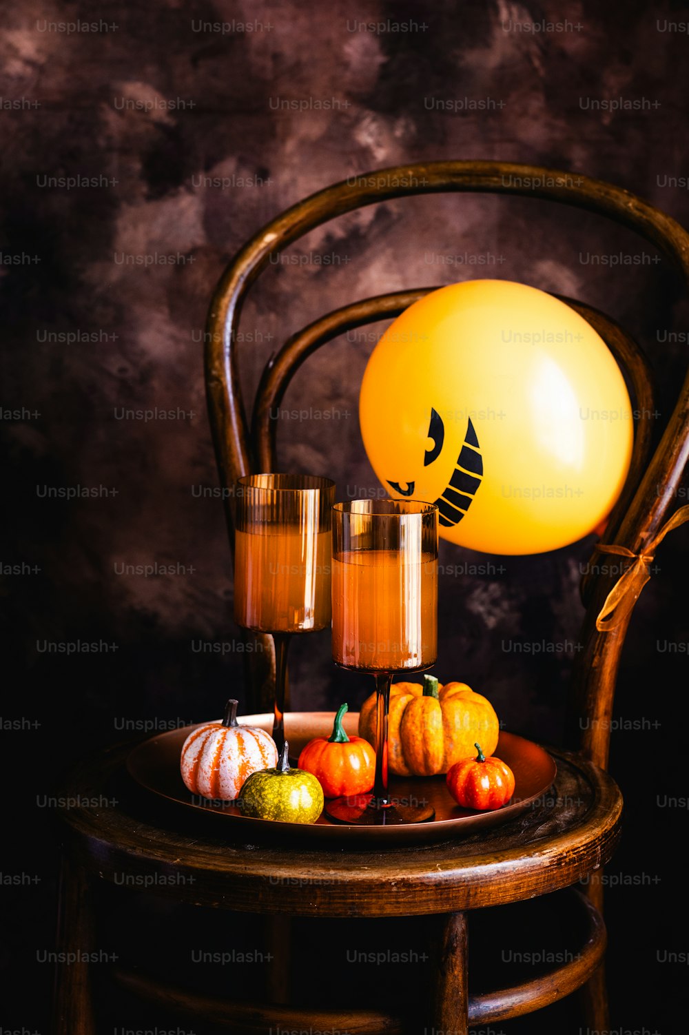 a wooden chair with candles and pumpkins on it
