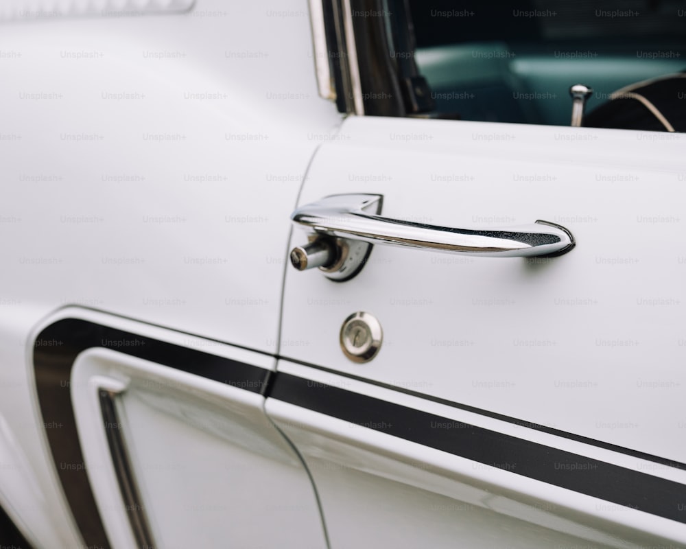 Un primer plano de la manija de una puerta en un coche blanco