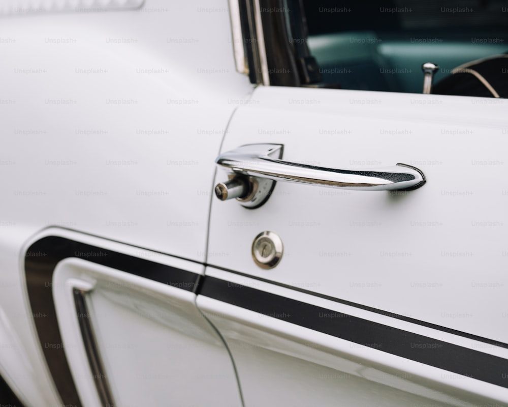 a close up of a door handle on a white car