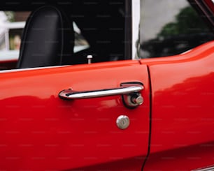 Un primer plano de la manija de una puerta en un coche rojo