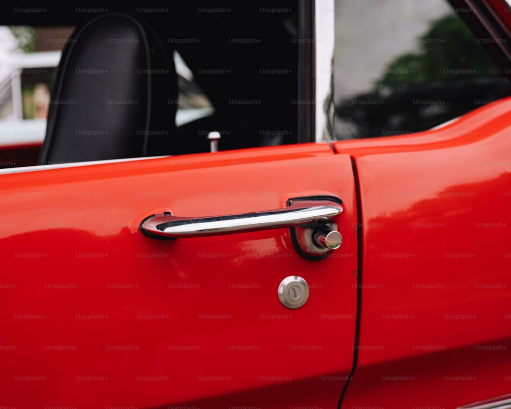 a close up of a door handle on a red car