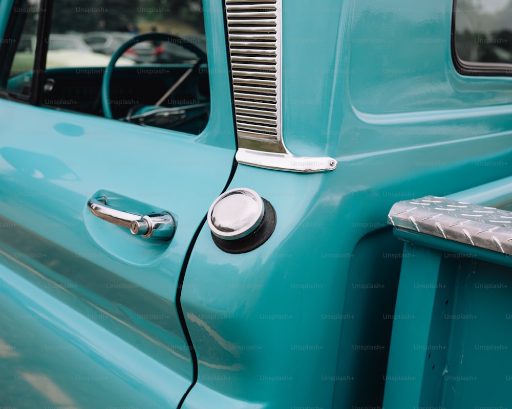 a close up of the door handle on a blue truck