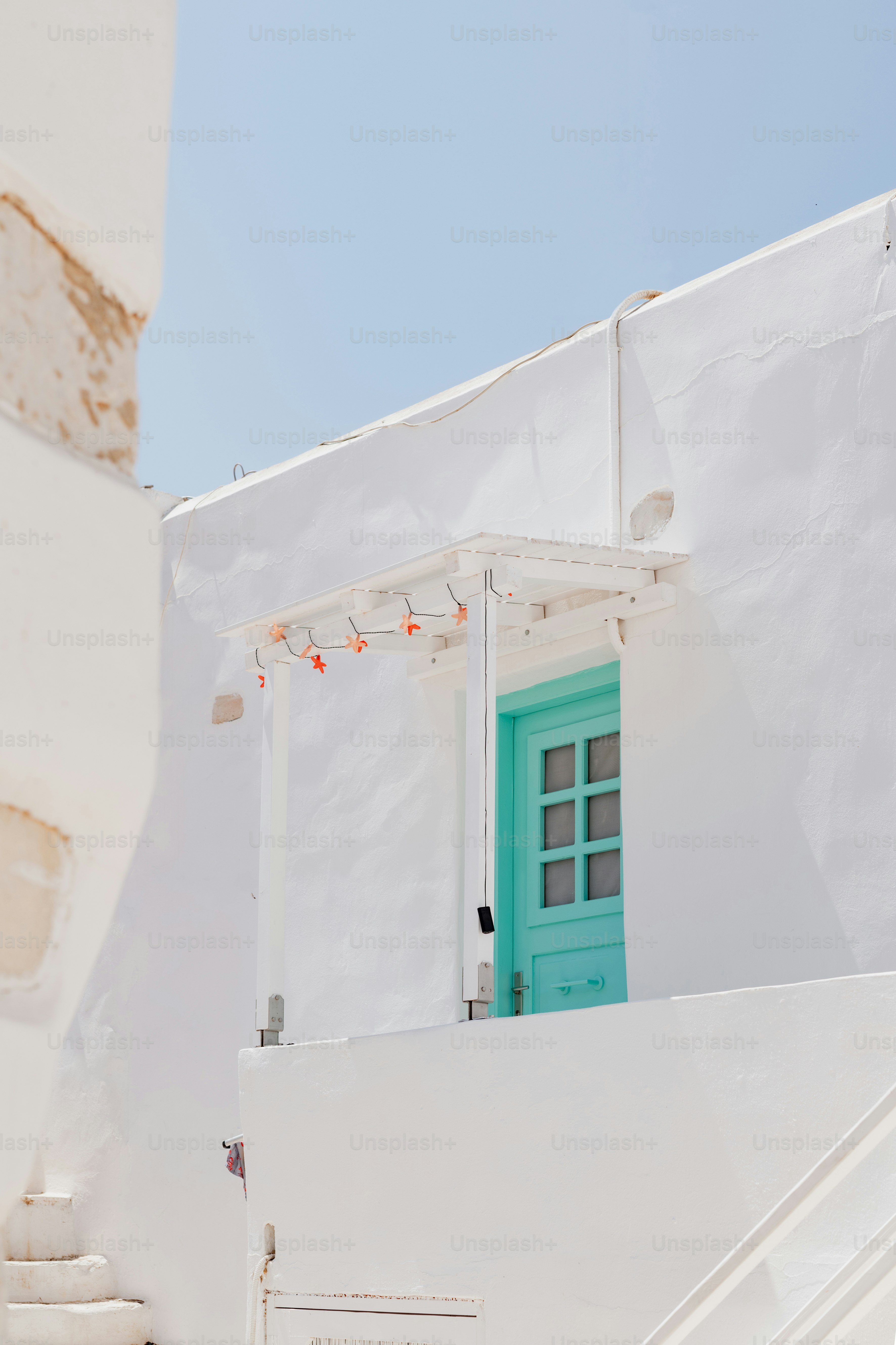 un bâtiment blanc avec une porte et une fenêtre vertes