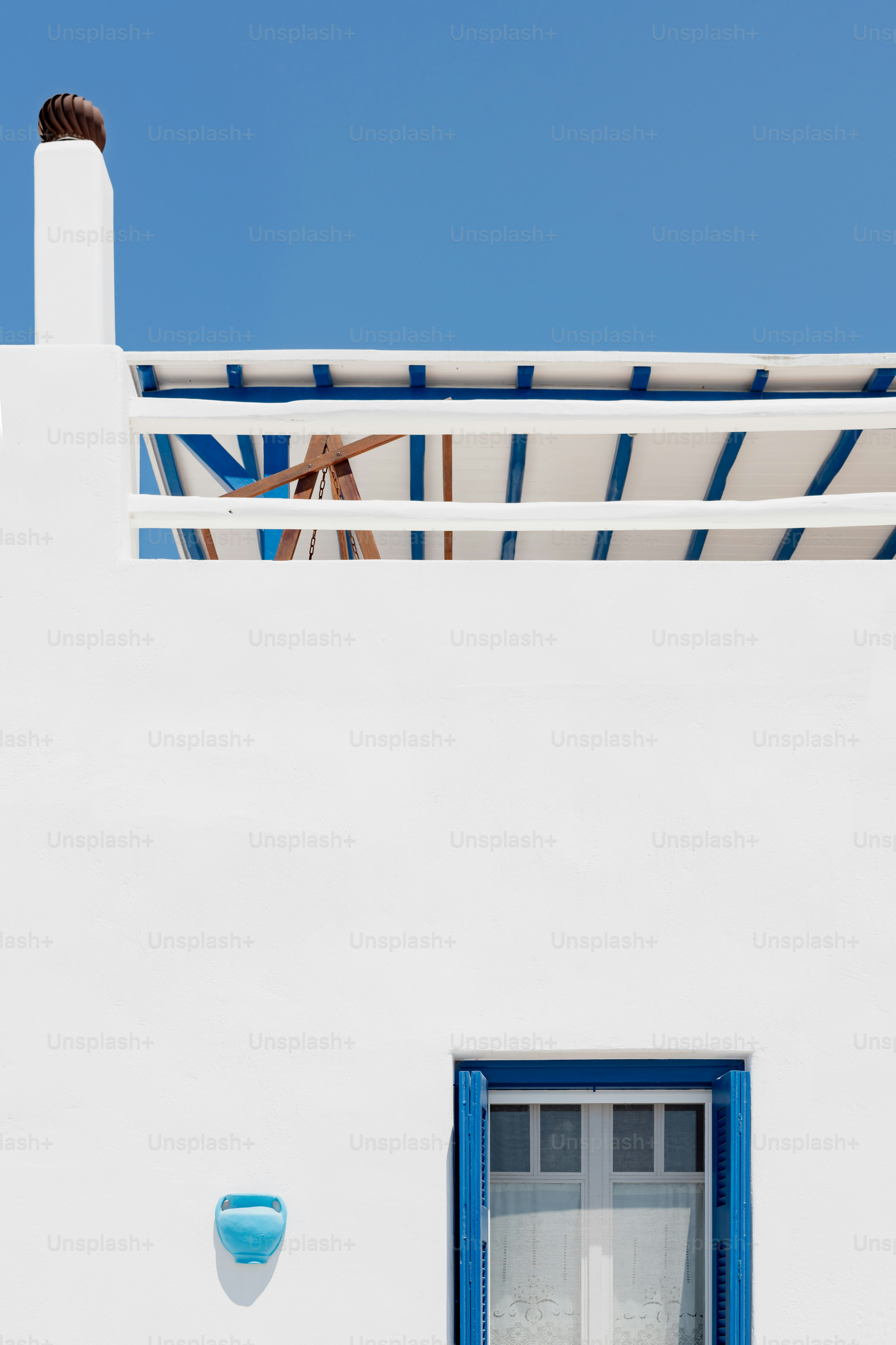 a white building with blue shutters and a clock