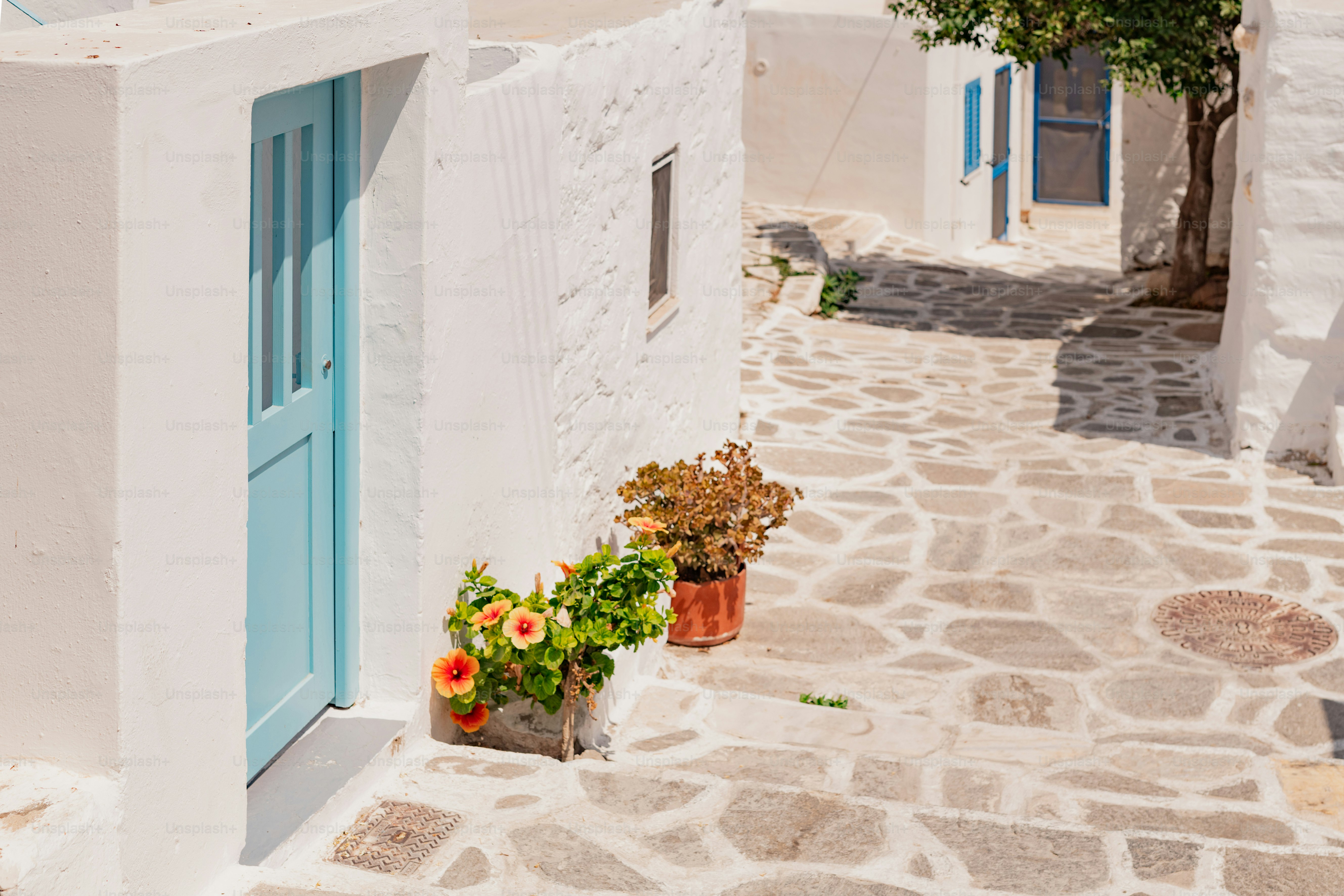 un petit bâtiment blanc avec une porte et une fenêtre bleues