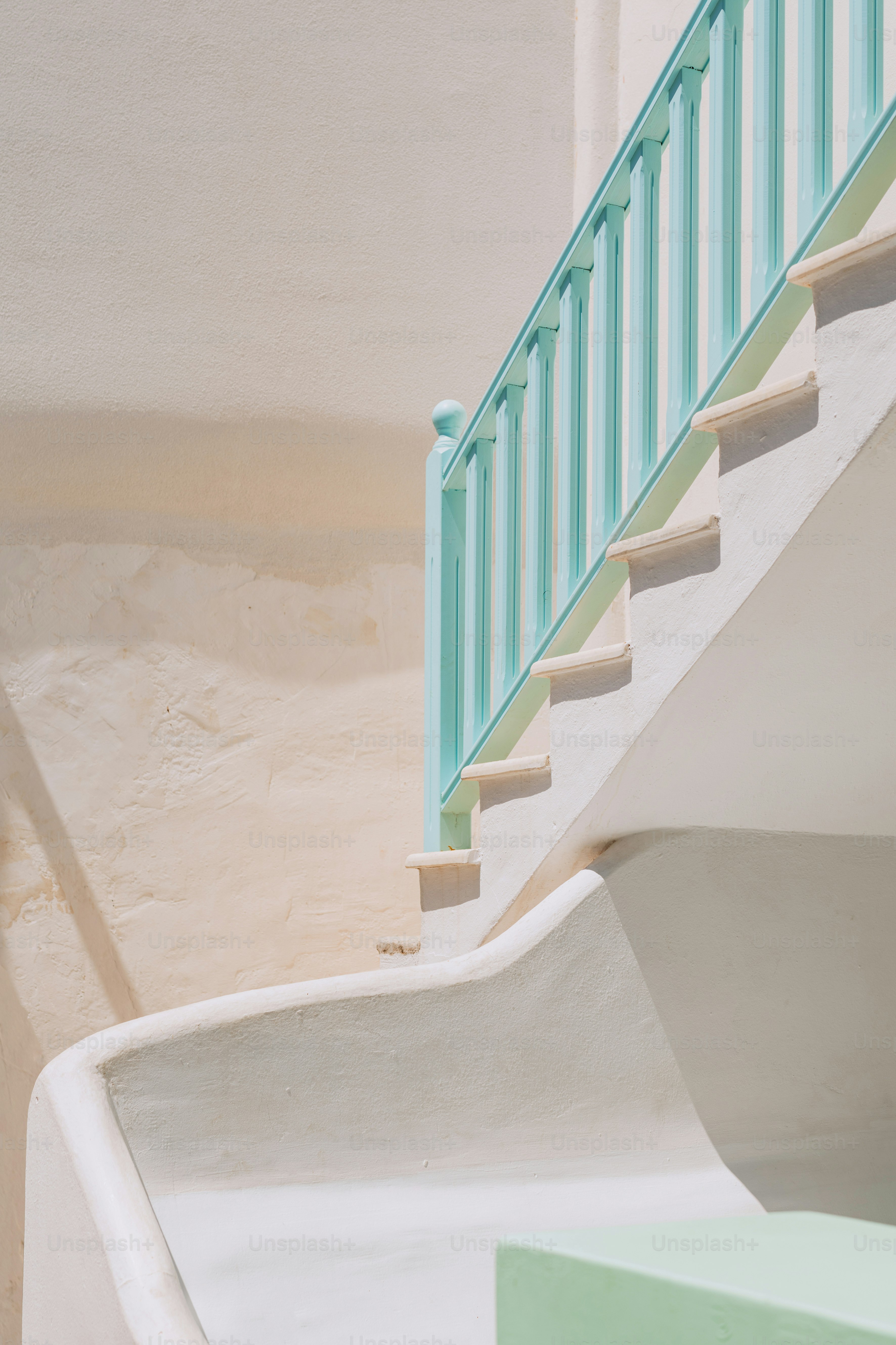 a green and white staircase next to a white building