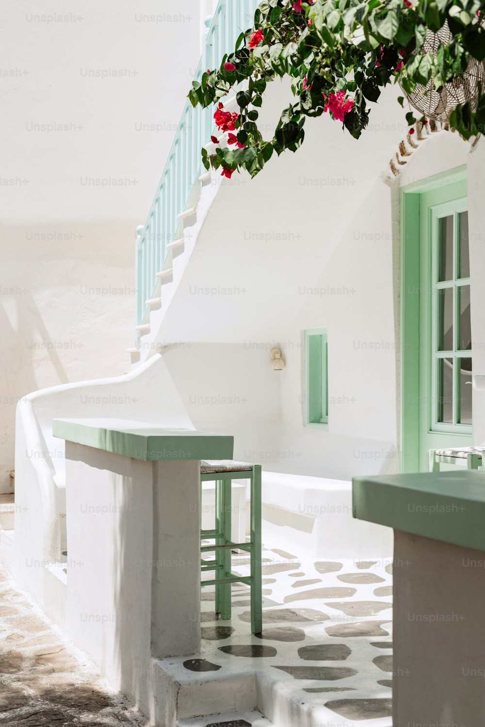 a white house with green shutters and a green door