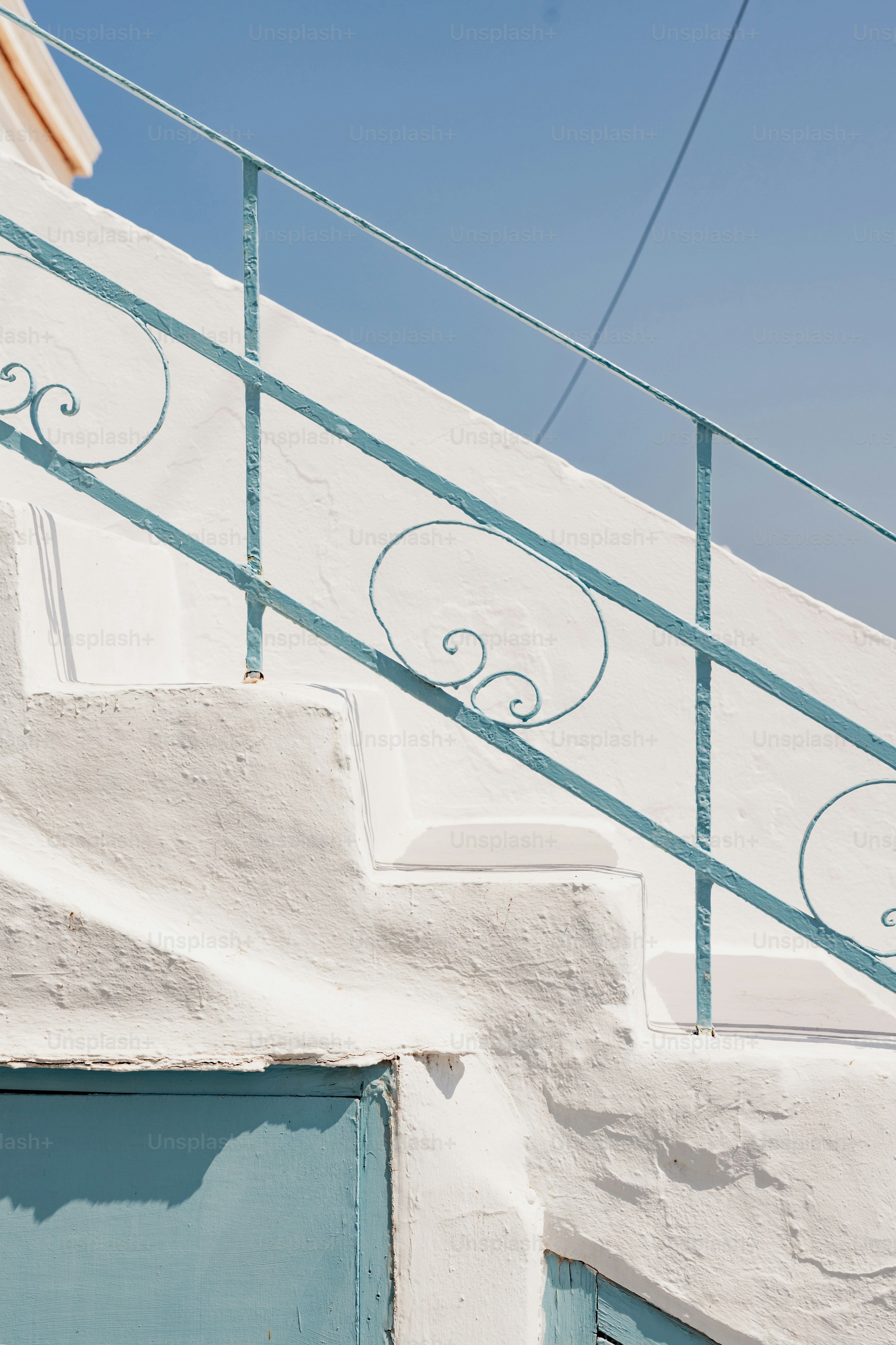 A white building with a blue door and railing photo – Greece Image on ...
