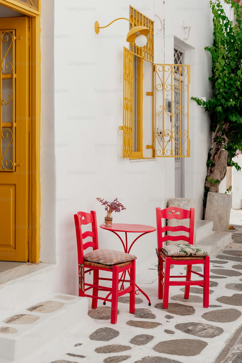 Un par de sillas rojas sentadas al lado de una mesa