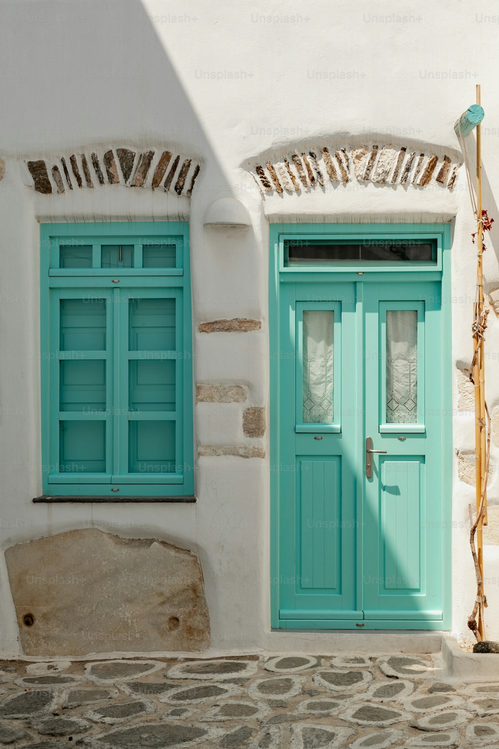 Una puerta y ventana azul en un edificio blanco