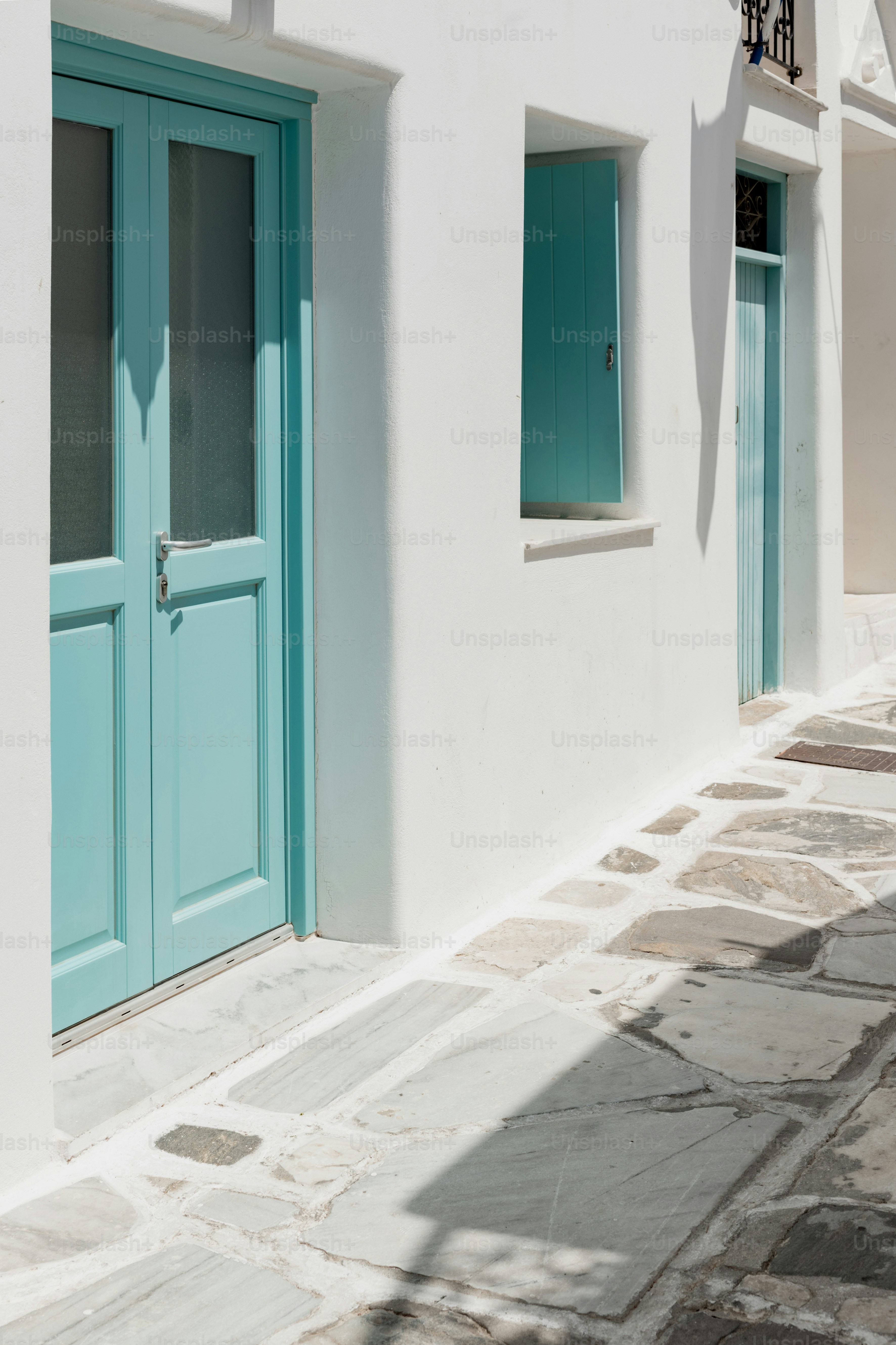 a white building with a blue door and windows
