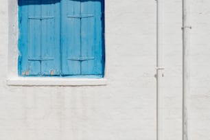 Ein weißes Gebäude mit blauer Tür und blauem Fenster
