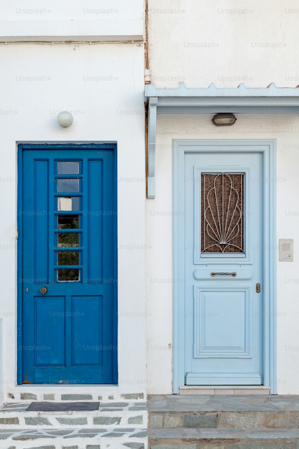 Eine blaue Tür und ein blaues Fenster an einem weißen Gebäude