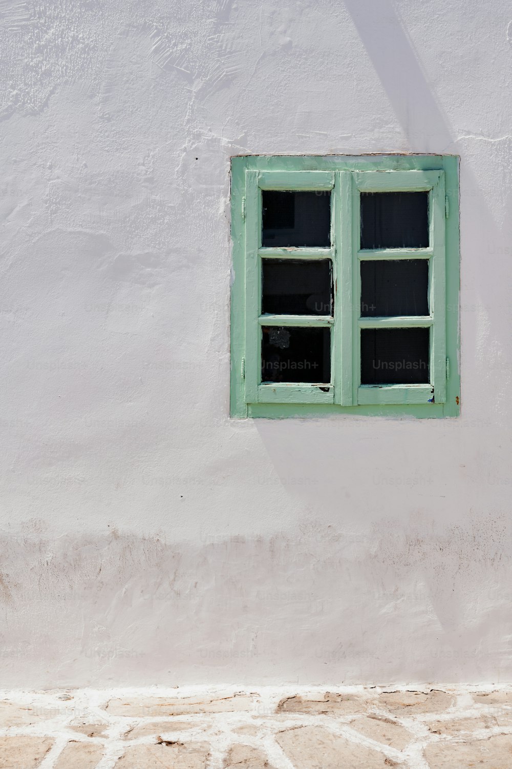 a white building with a green window on the side