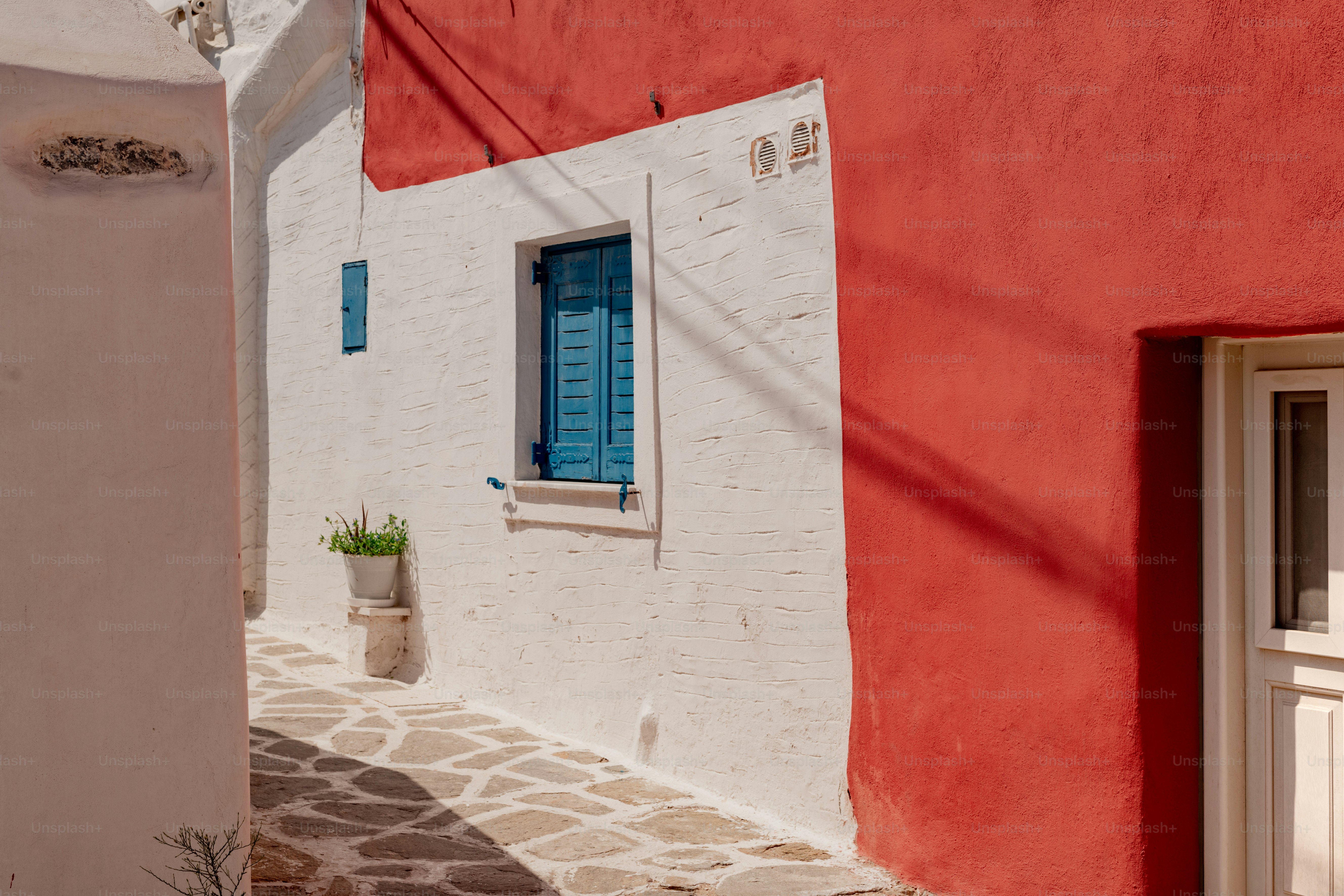 a red and white building with a blue window
