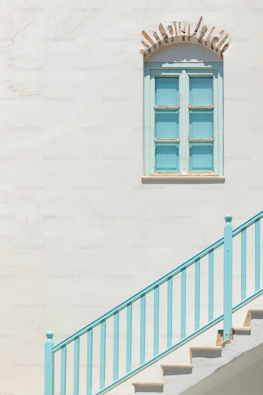 a white building with a blue railing and a window