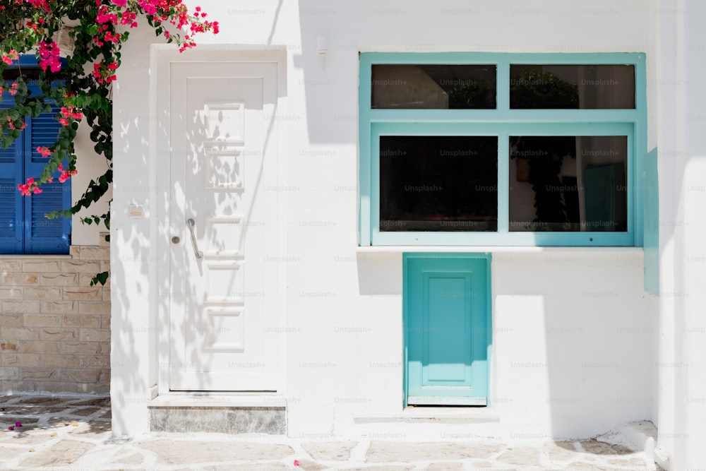 Ein weißes Gebäude mit blauer Tür und blauem Fenster