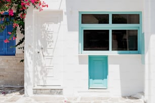 a white building with a blue door and window