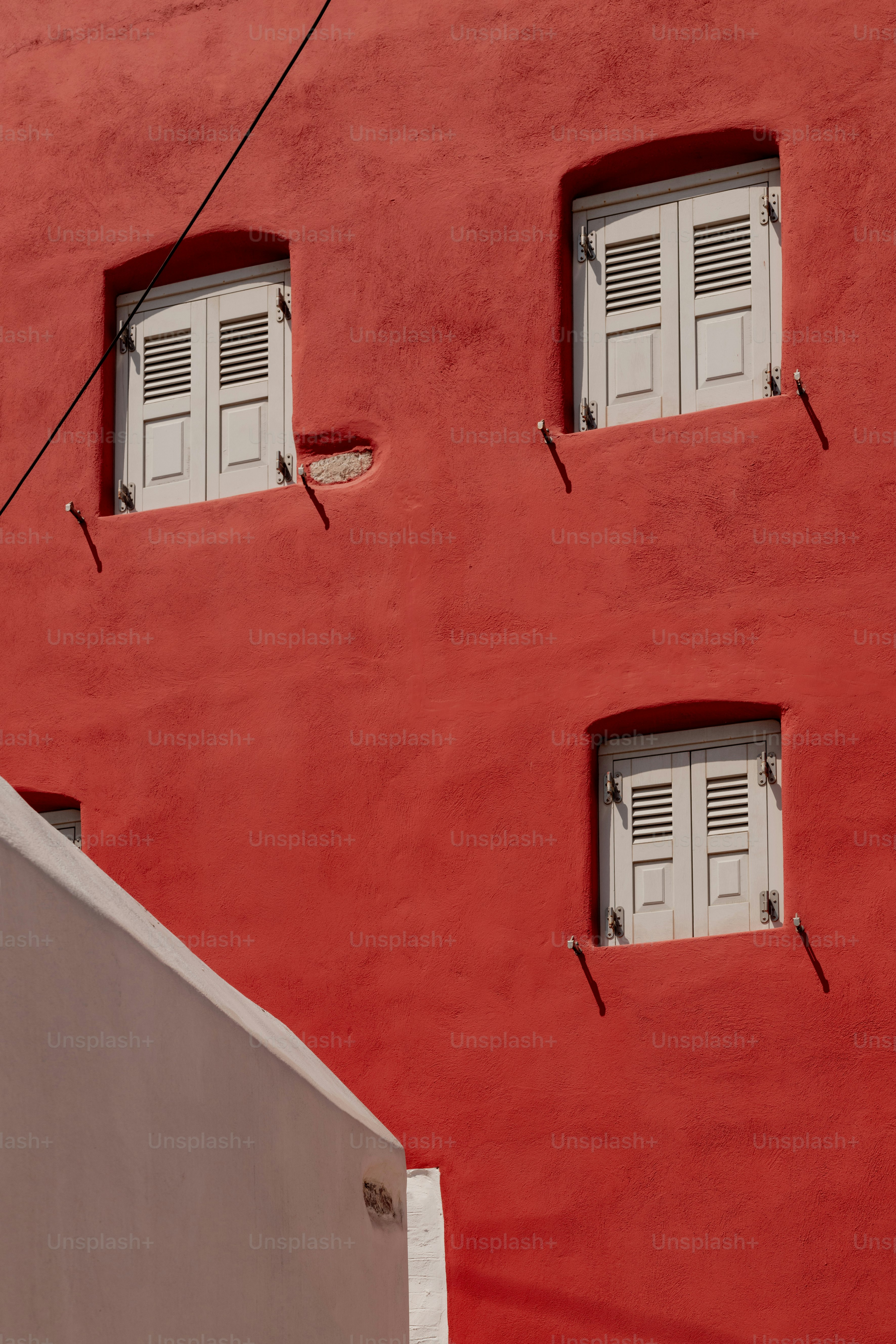 a red building with white shutters and windows